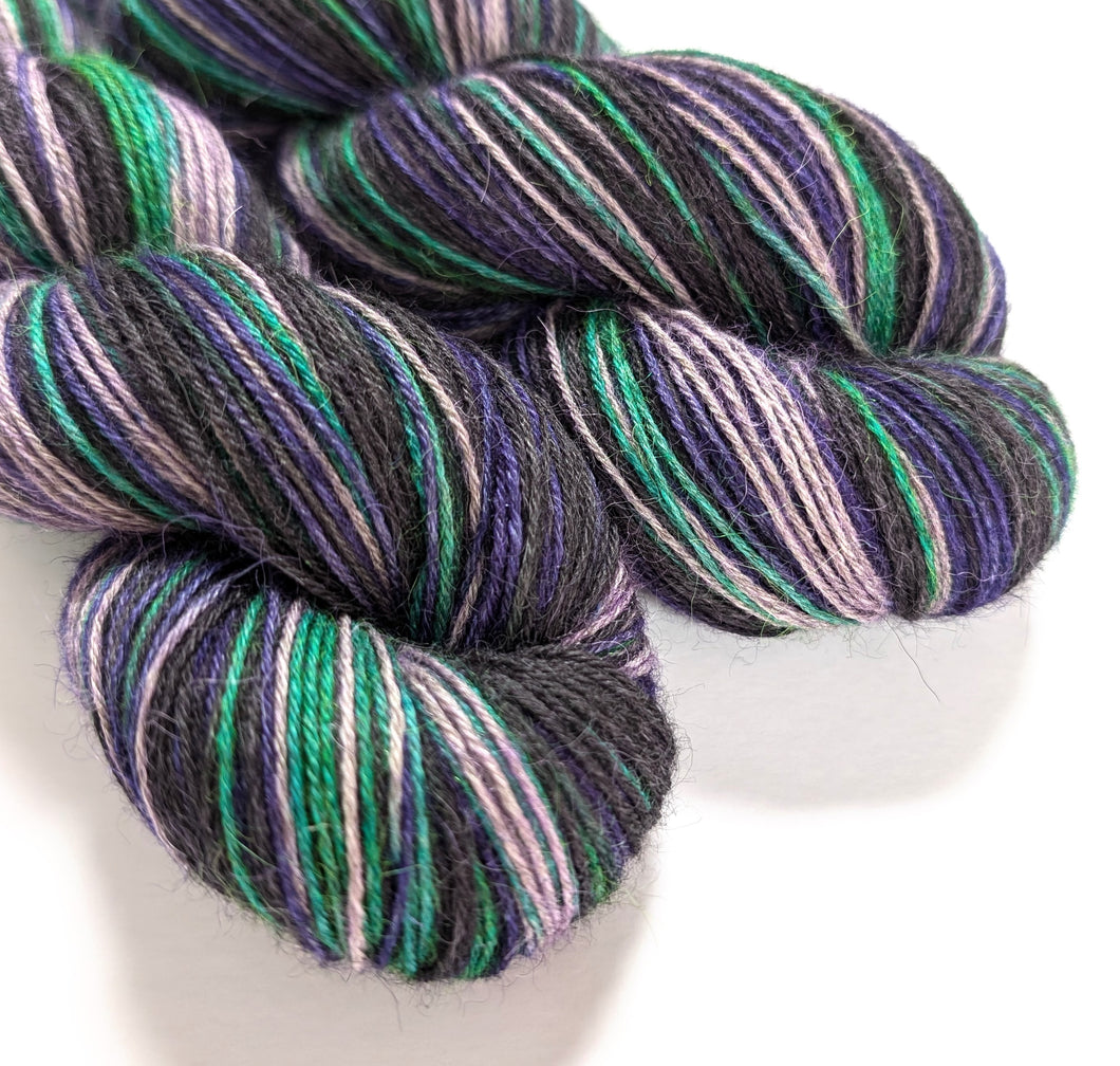 Witches' Brew on 100% llama 4ply/fingering weight yarn. Grey base.