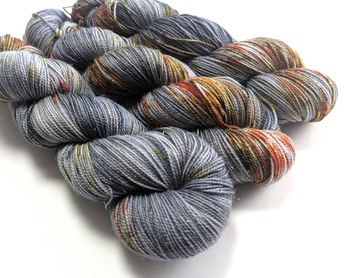 Grey  and rust yarn with sparkle, on a white background.