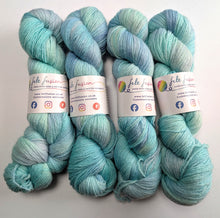 Load image into Gallery viewer, Four skeins of yarn on a white background.
