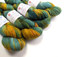 Load image into Gallery viewer, Green and gold yarn on a white background.
