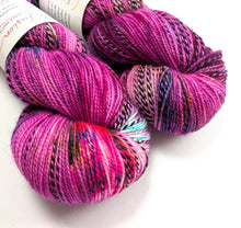 Load image into Gallery viewer, Two skeins of multicoloured yarn on a white background
