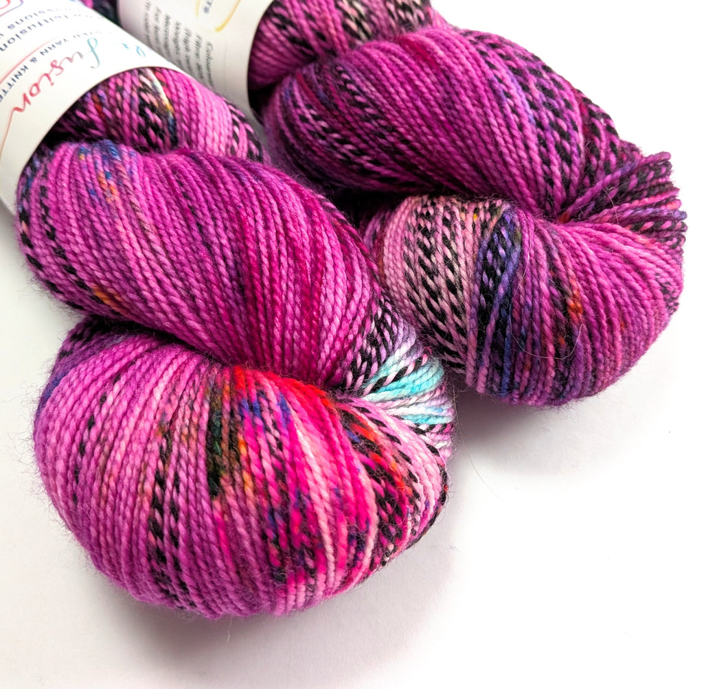 Two skeins of multicoloured yarn on a white background