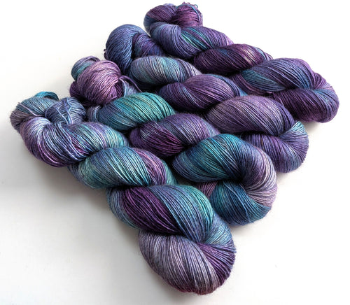 Four skeins of purple and blue yarn.
