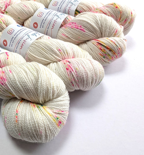 Spotted yarn skeins with visible branding on a white background