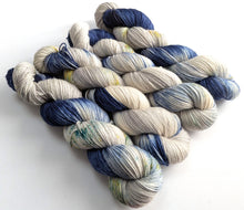 Load image into Gallery viewer, Four skeins of navy blue and silver grey yarn with speckles. 

