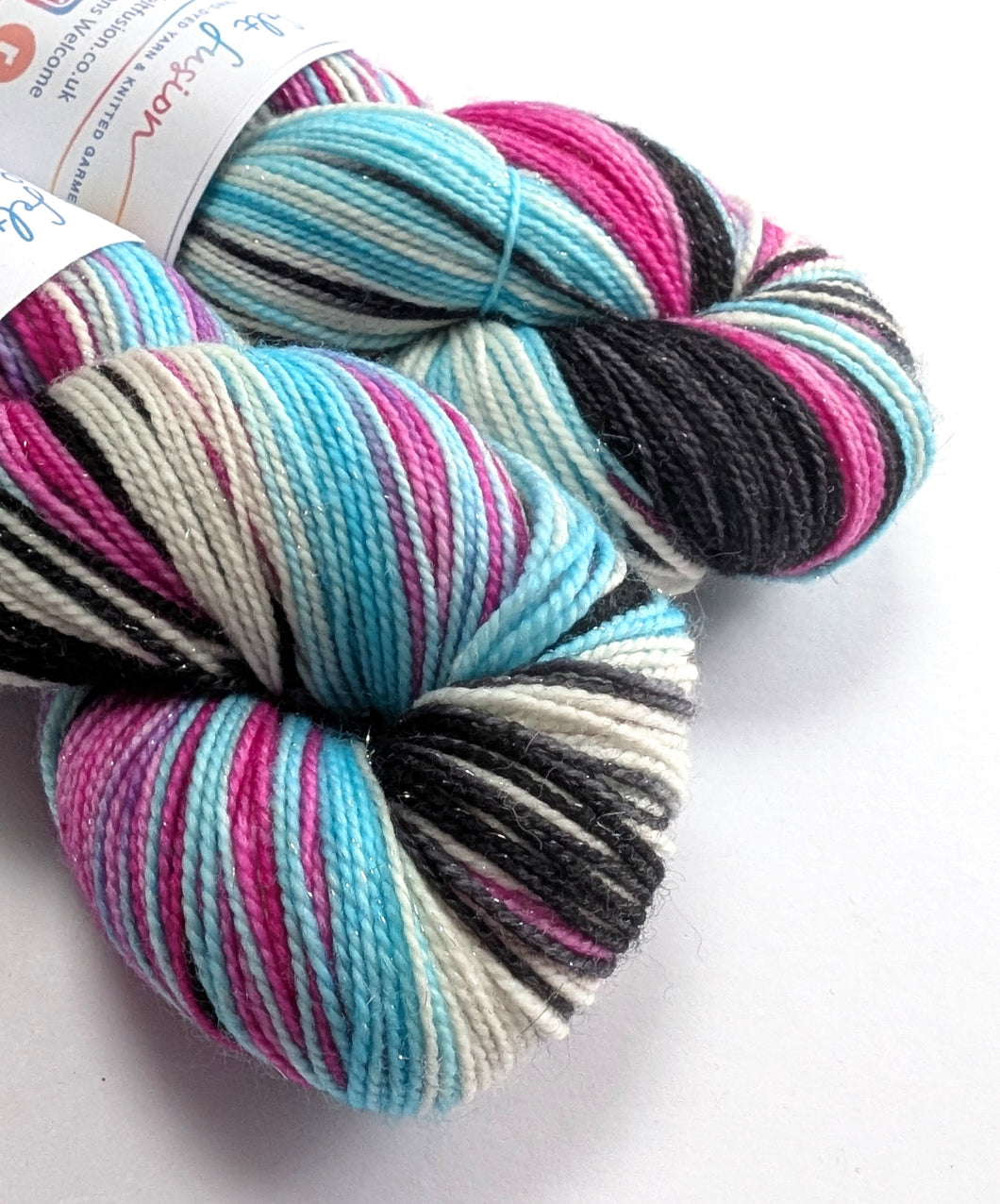 Multicolored skein of yarn with a visible brand label on a white background