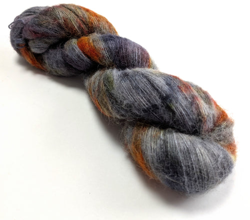 Grey and rust skein of yarn on a white background
