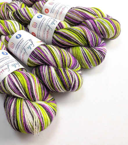Four skeins of multicolored yarn with labels on a white background