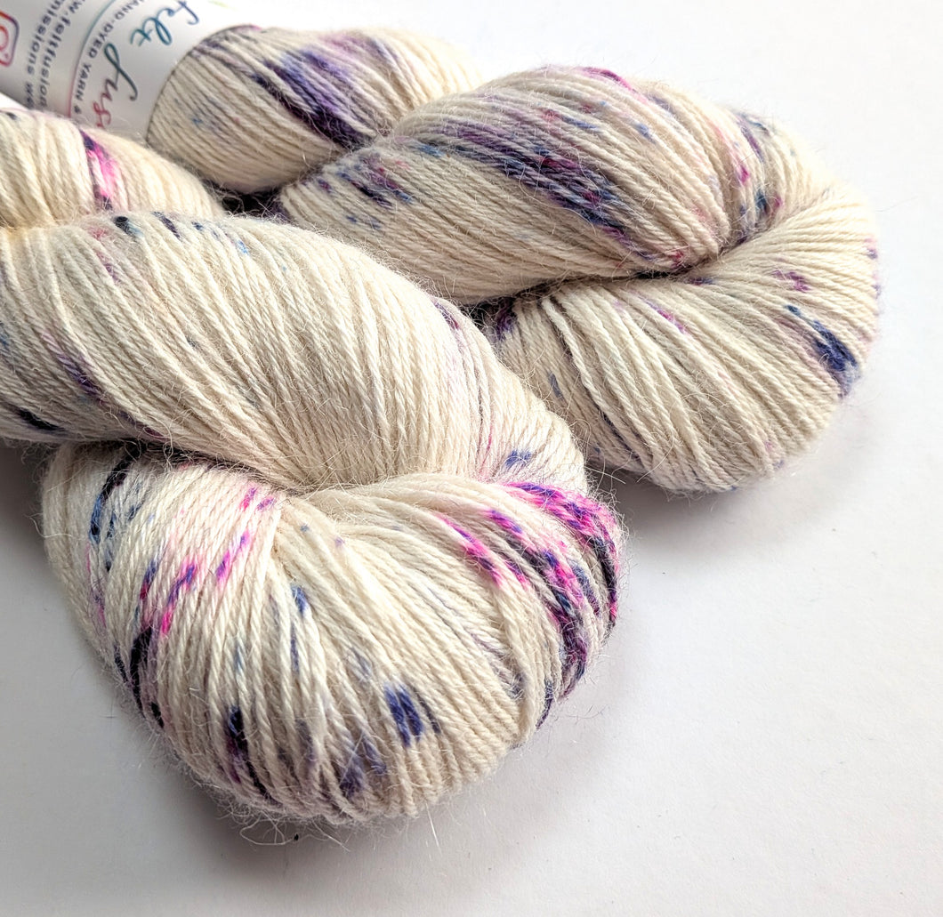 Two skeins of speckled yarn on a white background