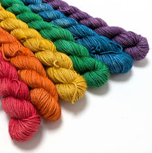Load image into Gallery viewer, Set of colorful yarn skeins arranged in a rainbow pattern on a white background
