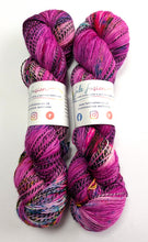 Load image into Gallery viewer, Two skeins of multicolored yarn with visible brand labels on a white background

