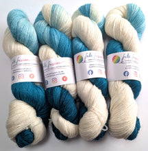 Load image into Gallery viewer, Four skeins of teal and white yarn with felt fusion labels on a white background
