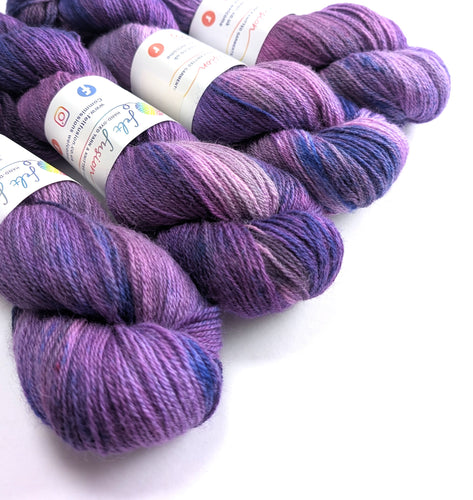 Purple yarn skeins with labels on a white background