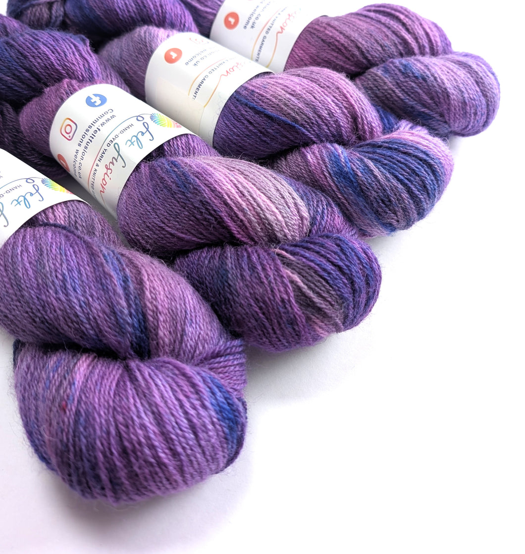 Purple yarn skeins with labels on a white background