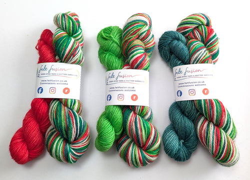 Three sets of Christmas themed yarn with visible branding on a white  background