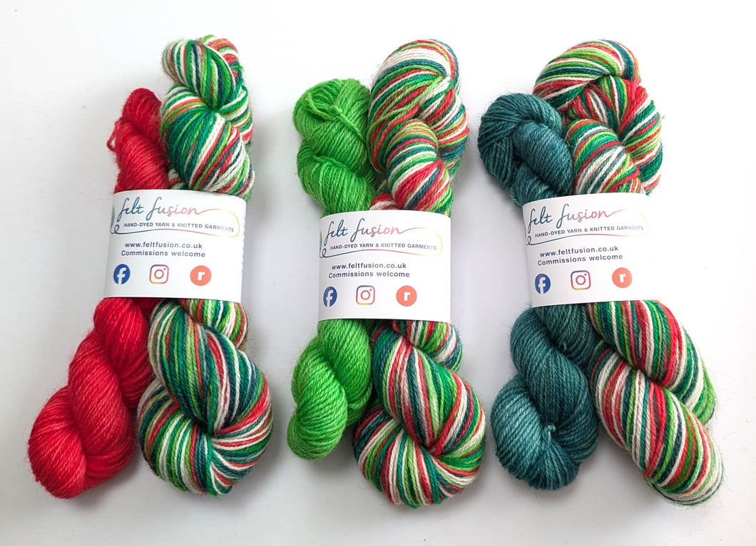 Three sets of Christmas themed yarn with visible branding on a white  background