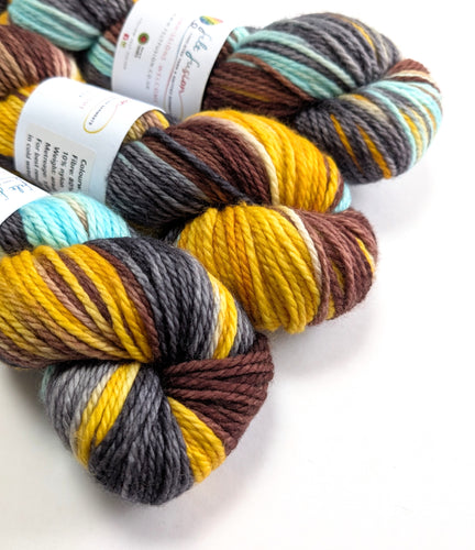 Three skeins of multicolored yarn with labels on a white background