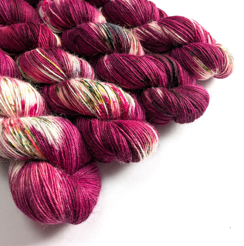 Skeins of pink and red yarn on a white background