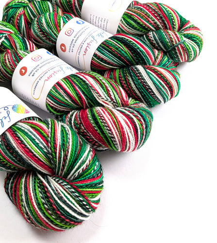 Four skeins of multicoloured yarn with labels on a white background
