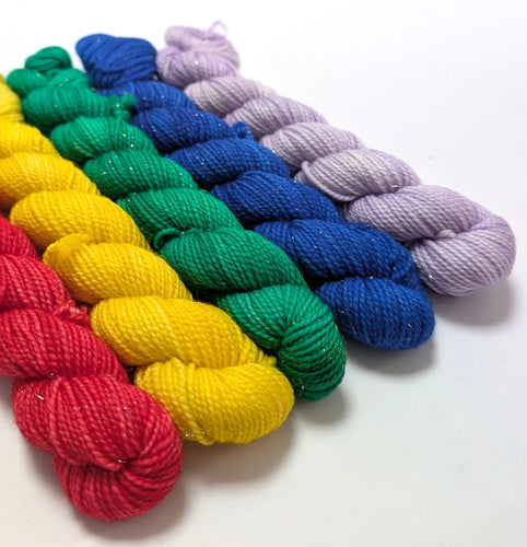 Colorful yarn skeins arranged in a row on a white background