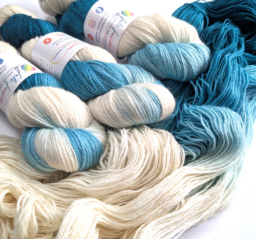 Yarn skeins in teal and white on a white background