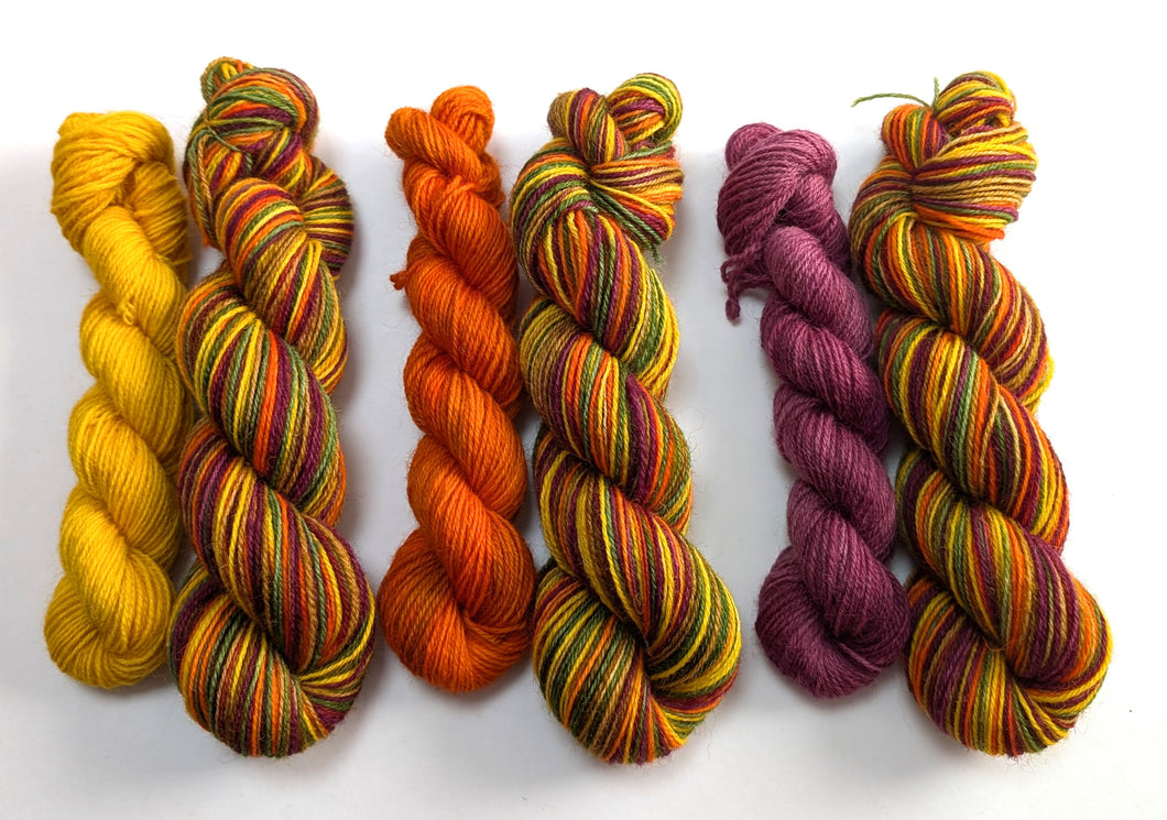 Colorful skeins of yarn in various patterns on a white background