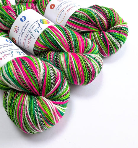 Colorful skeins of yarn with visible brand labels on a white background
