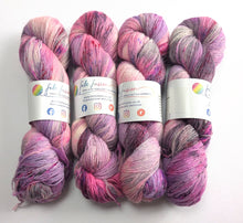 Load image into Gallery viewer, Four skeins of multicolored yarn with visible brand labels on a white background
