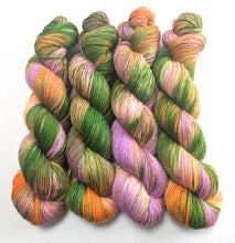 Load image into Gallery viewer, Multicolored yarn skeins in green, orange, and purple on a white background
