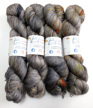 Load image into Gallery viewer, Four skeins of gray and brown yarn with colorful speckles.
