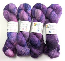 Load image into Gallery viewer, Four skeins of purple yarn with colorful labels on a white background
