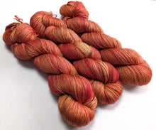 Load image into Gallery viewer, Bunch of red and orange yarn skeins on a white background
