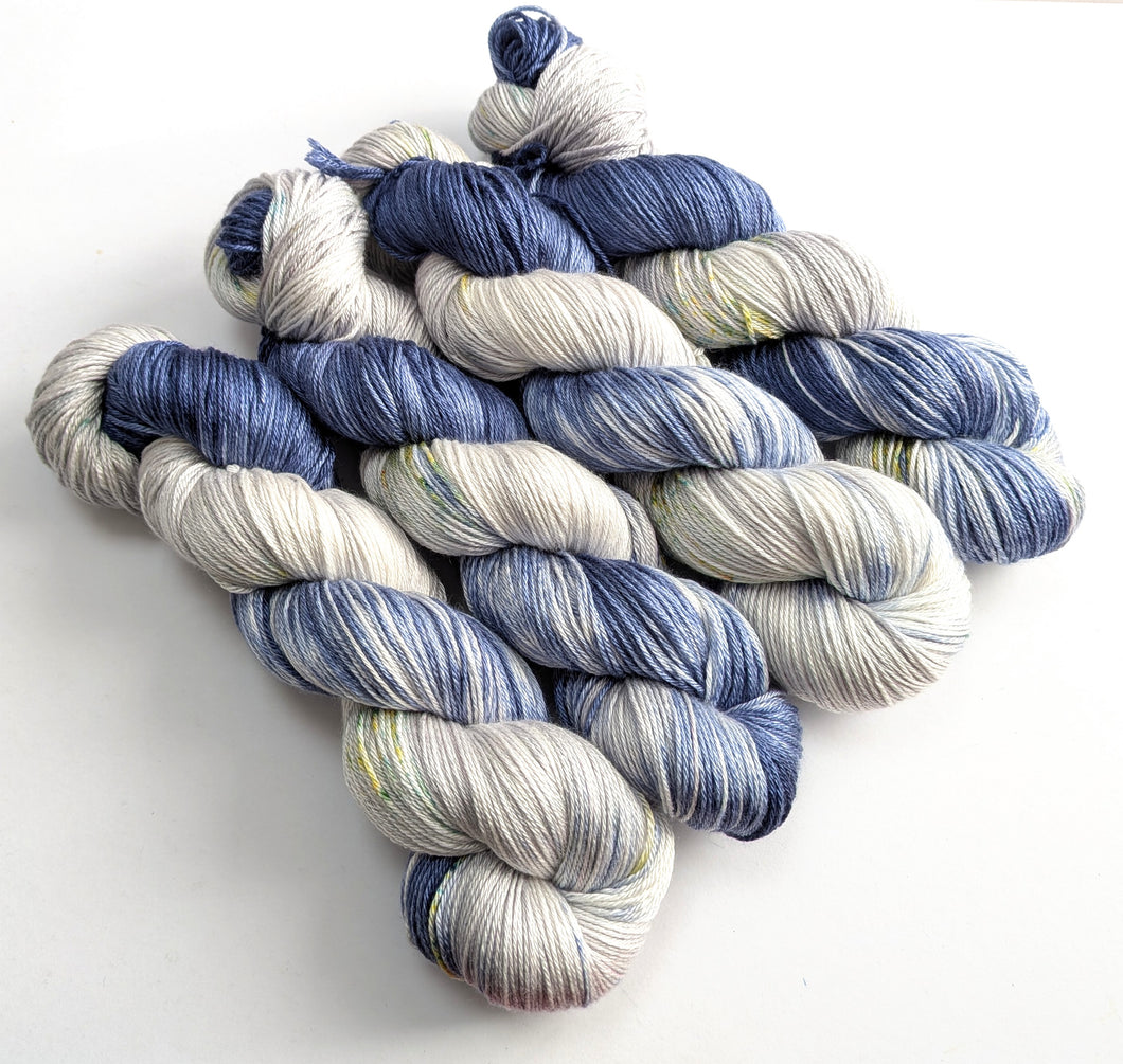 Four skeins of navy and silver yarn with speckles.
