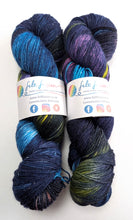 Load image into Gallery viewer, Two skeins of multicolored yarn with visible brand labels on a white background

