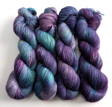 Load image into Gallery viewer, Four skeins of blue and purple variegated yarn.
