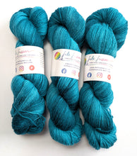 Load image into Gallery viewer, Three skeins of blue-green yarn with felt fusion labels on a white background
