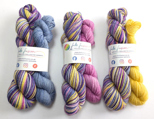 Three sets of multicolored yarn with visible branding on a white background