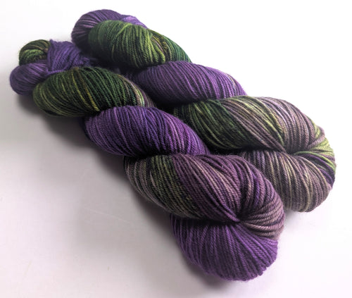 Purple and green yarn skeins on a white background