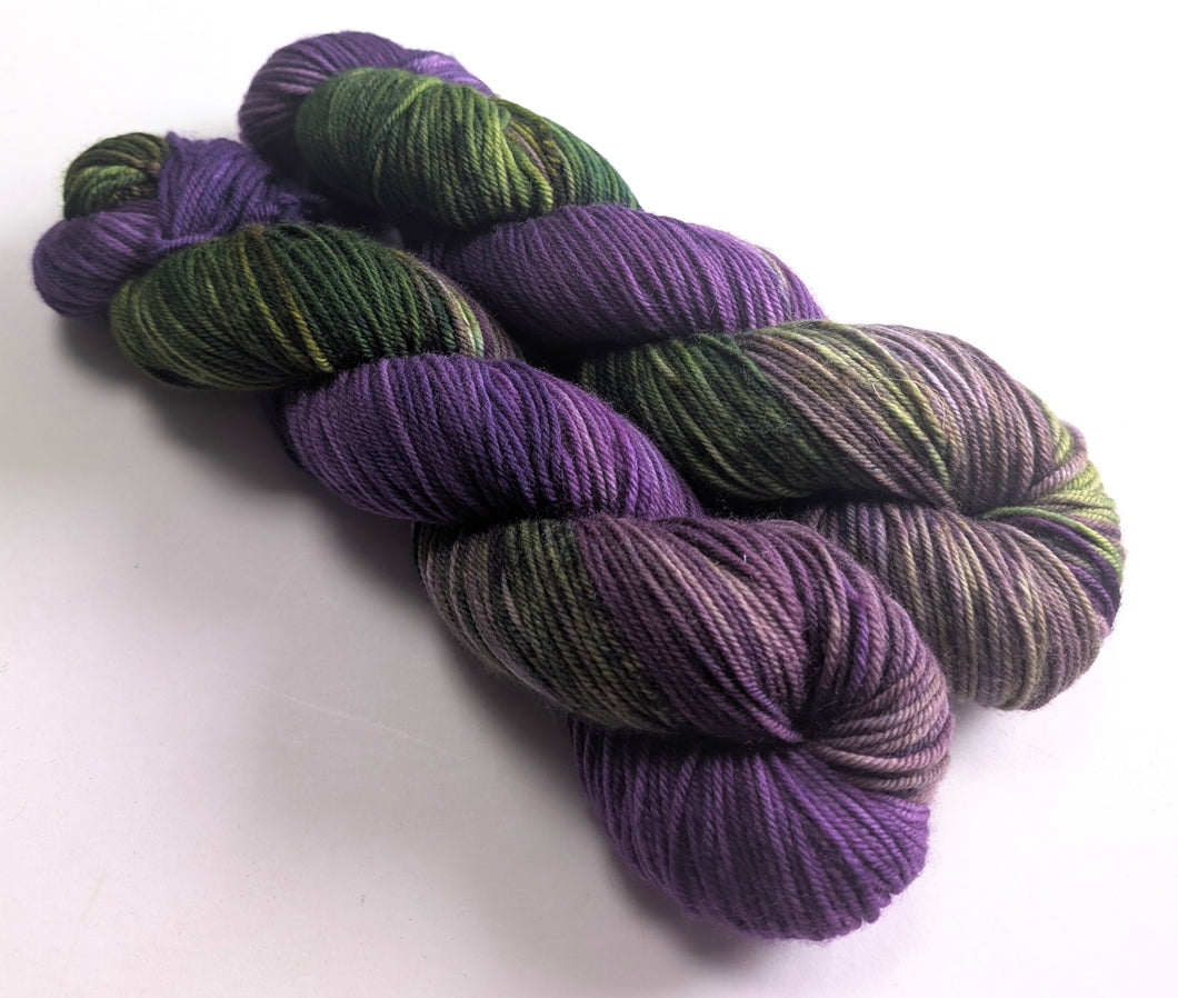 Purple and green yarn skeins on a white background