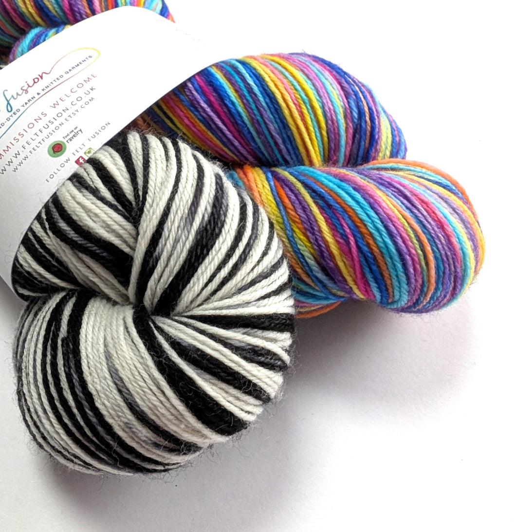 Two skeins of yarn, one black and white, one multicoloured.