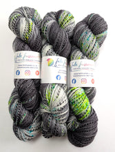 Load image into Gallery viewer, Three skeins of grey and green yarn with labels on a white background
