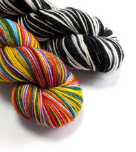 Load image into Gallery viewer, Two skeins of yarn, one multicolored and one black and white striped, on a white background.
