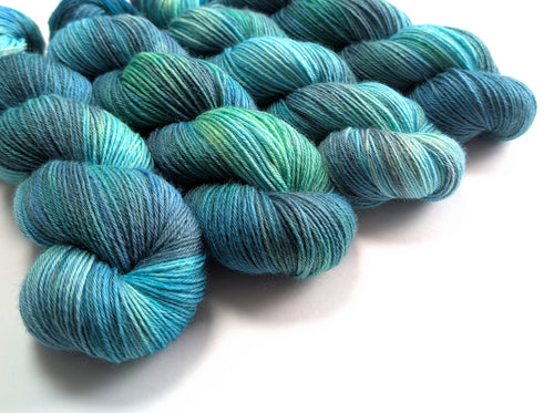 Blue and green yarn skeins on a white background