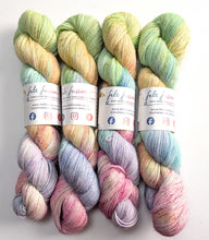 Load image into Gallery viewer, Four skeins of multicolored yarn with visible branding on a white background
