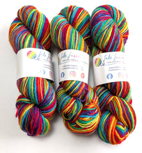 Load image into Gallery viewer, Three skeins of colorful yarn with visible branding on a white background
