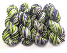 Load image into Gallery viewer, Green, purple, and white yarn skeins on a white background
