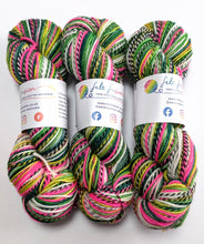 Load image into Gallery viewer, Three skeins of multicolored yarn with visible branding on a white background
