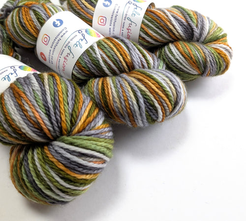 Three skeins of multicolored yarn with labels on a white background