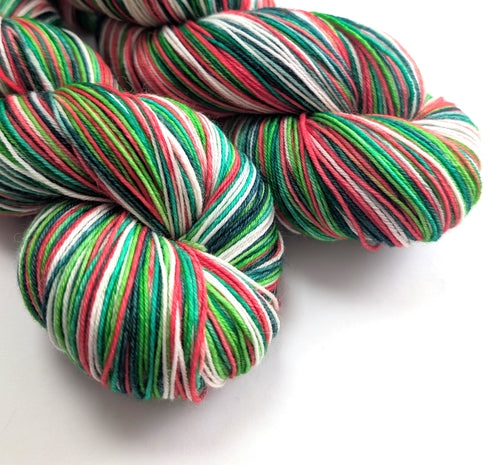 Colorful red, green and white yarn skeins on a white background