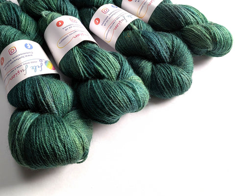 Green yarn skeins with labels on a white background